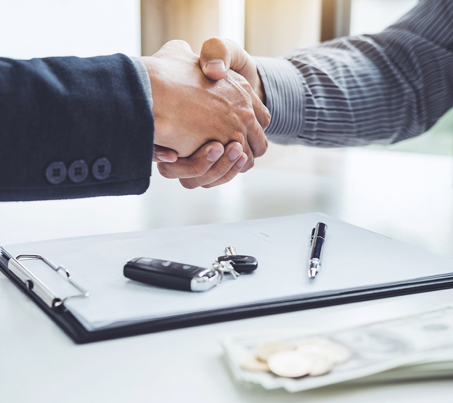 Shaking hands over paperwork